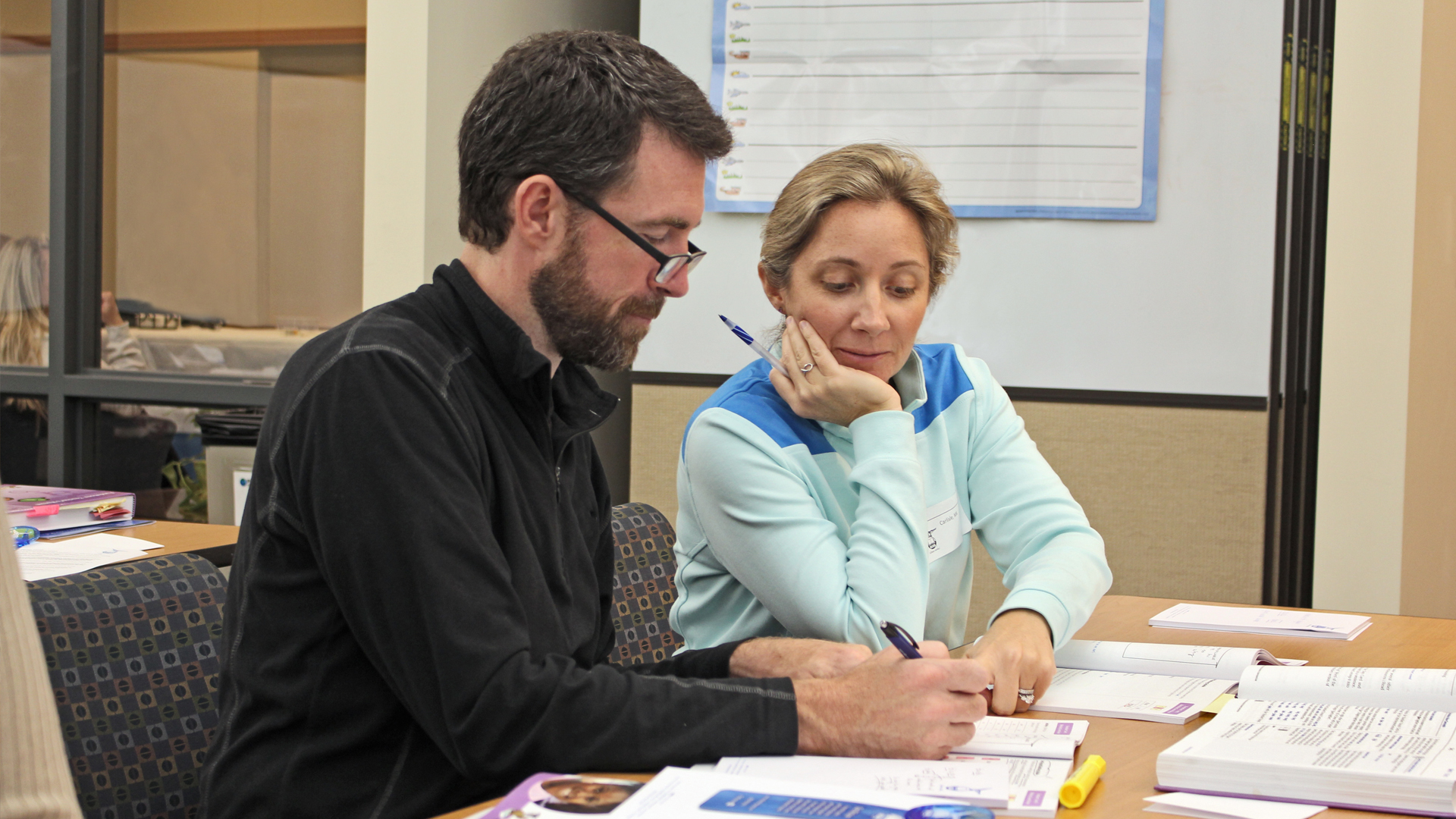 Man and woman collaborating on training materials