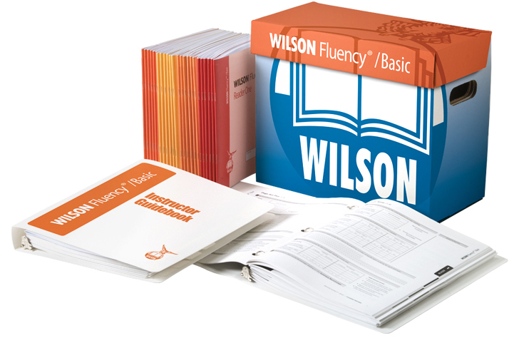 Wilson Fluency Basic® instructional materials, including a box, guidebook, and reader set.
