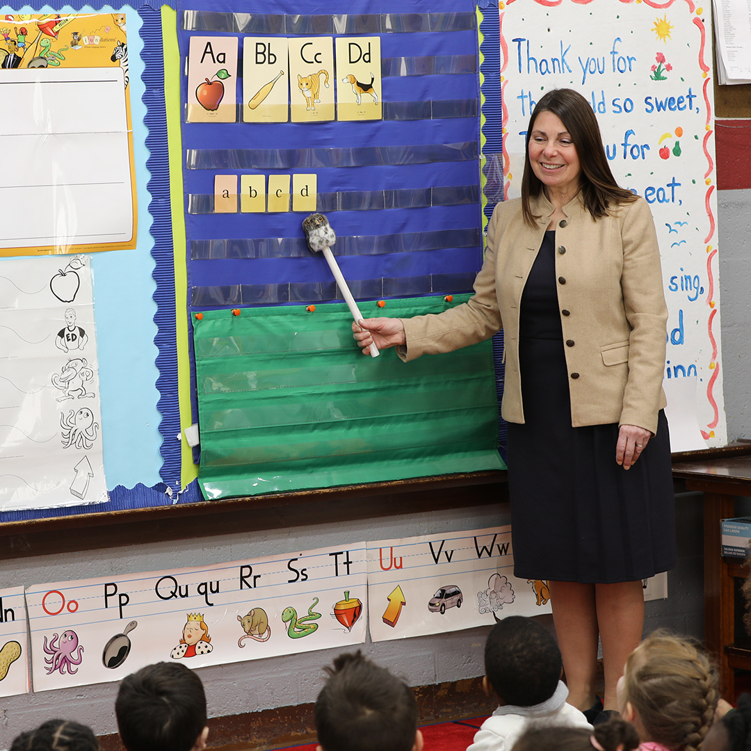Teacher points to alphabet chart in Pre-K activity set