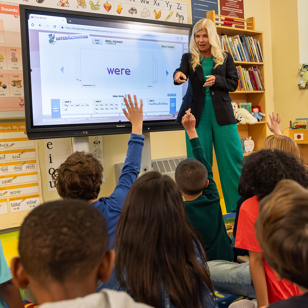 Teacher points to screen displaying "were" in Fundations® lesson.