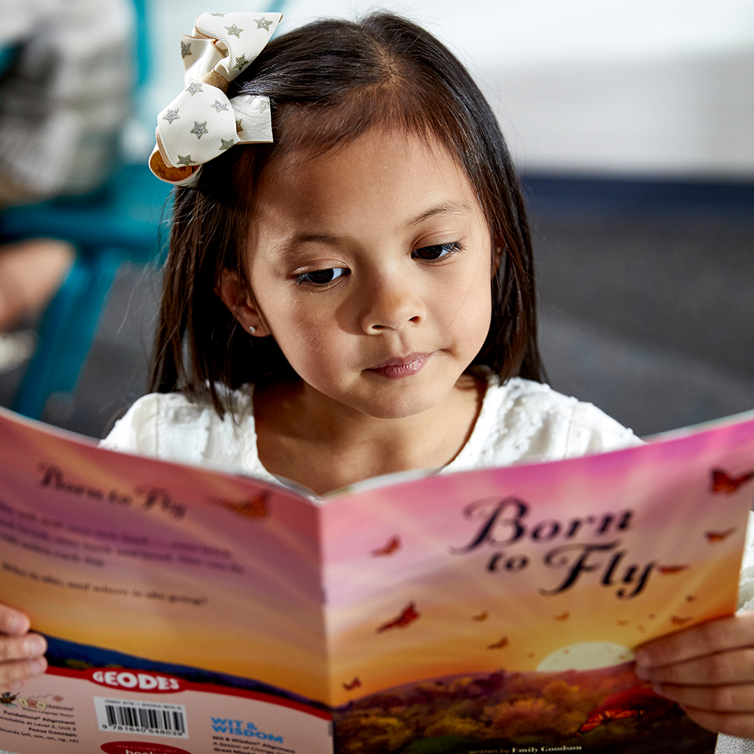 Young girl reads "Born to Fly" Geodes book about butterflies