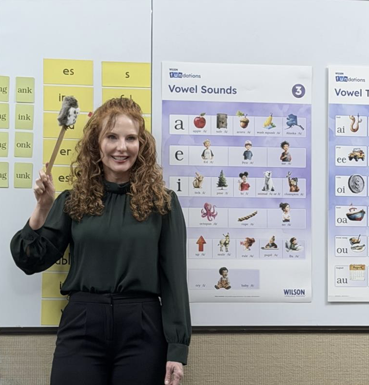 Instructor at a Fundations workshop pointing to vowel sounds chart