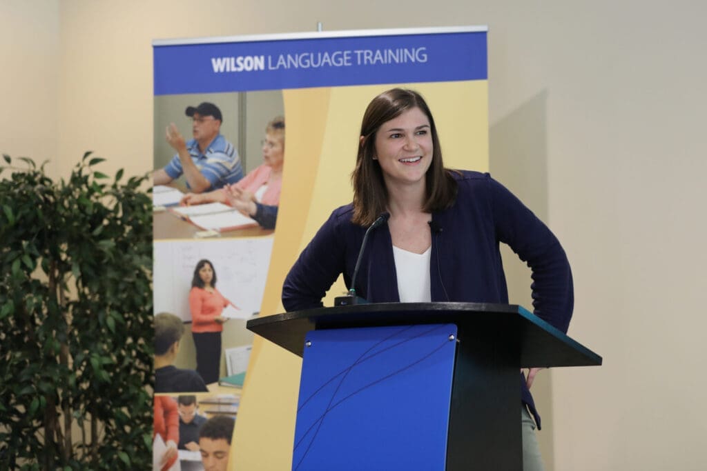 Woman speaking at Wilson Language Training podium, careers in language education