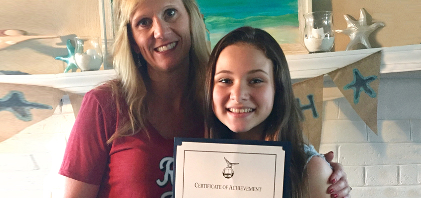 Teen advocate proudly holds a Certificate of Achievement with her mother.