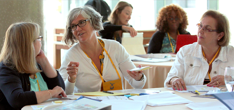 Women in a meeting discussing documents at a table
