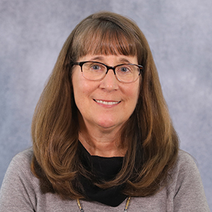 Woman with glasses and long brown hair, educator for phonemic awareness and word study.