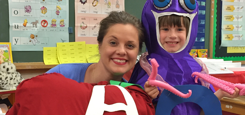 YMCA book club: Woman and child in octopus costume with large letter A
